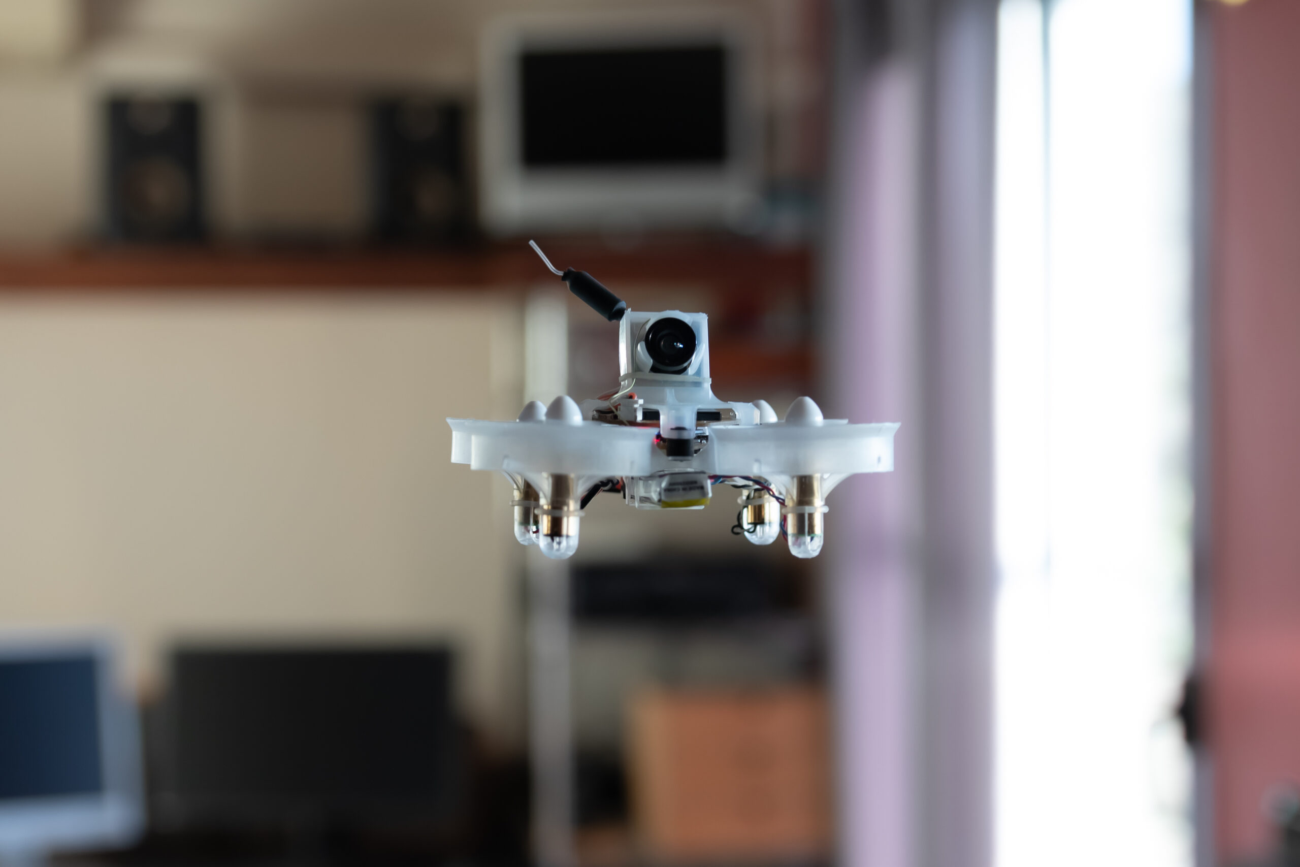 Micro spy drone flying inside a house. Remote controlled nano air vehicle with a small camera.
