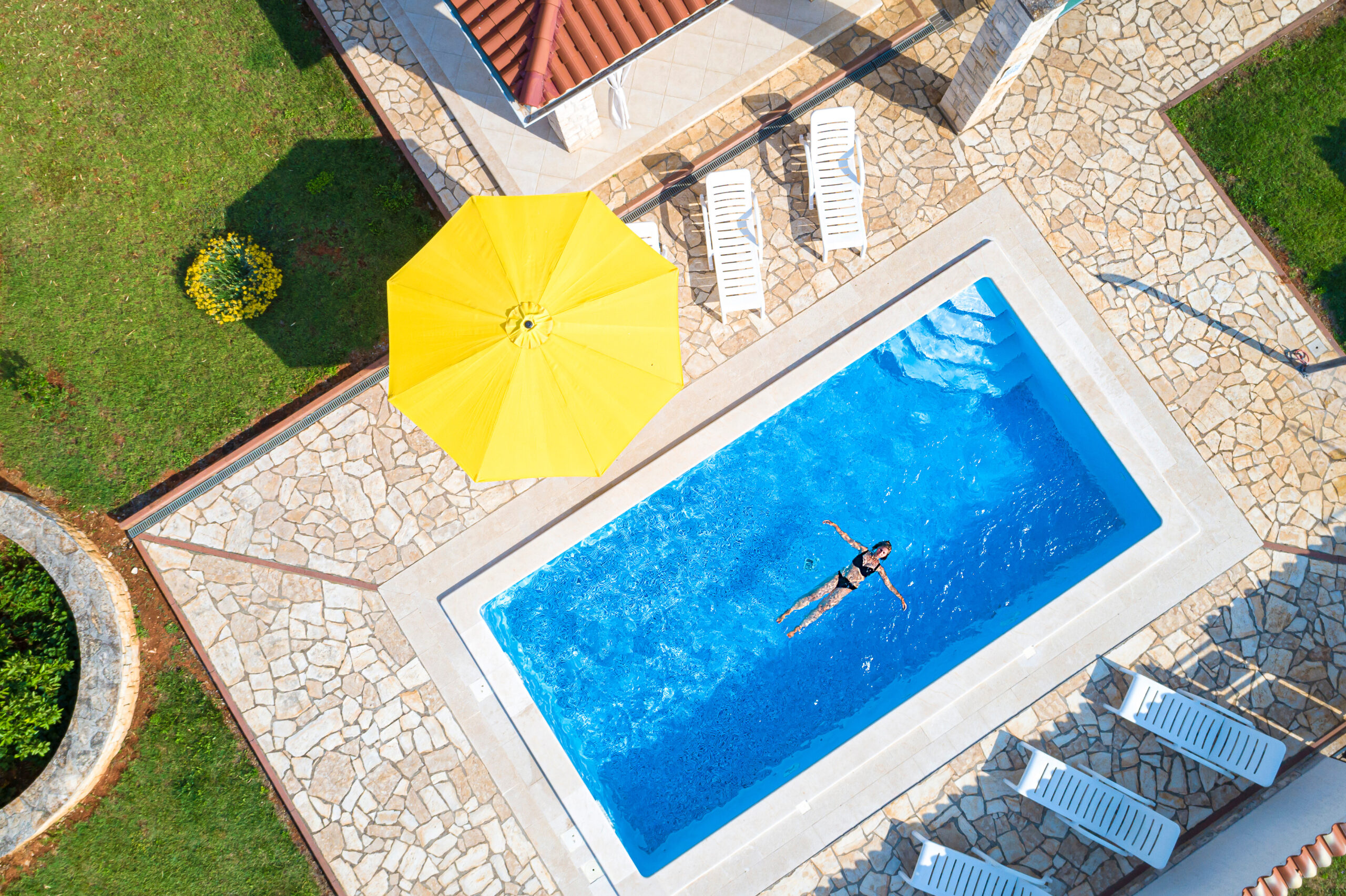 Croatia, Istria, Pula, mother and daughter swimming at the pool, birds eye view